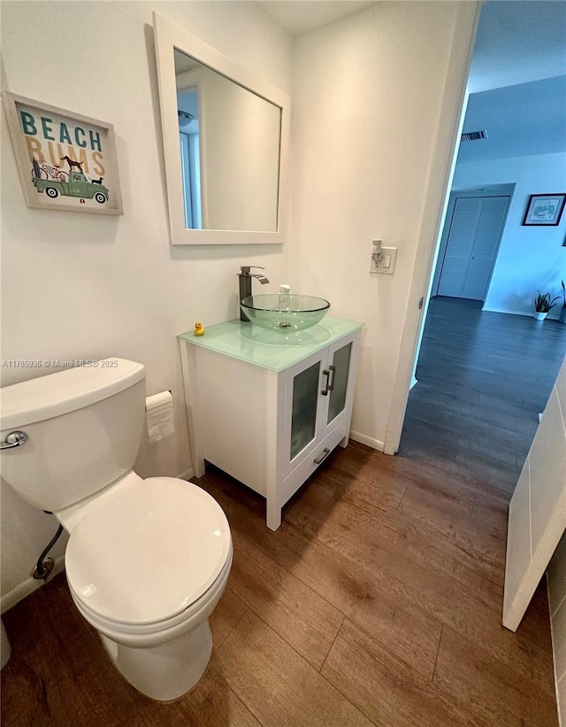 575 Crandon Blvd Unit 707, Key Biscayne, FL 33149 - bathroom with wood finished floors, visible vents, toilet, vanity, and baseboards
