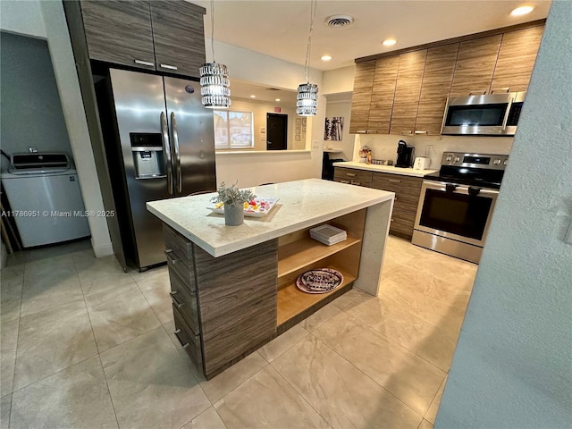 5424 Garfield St, Hollywood, FL 33021 - kitchen with light tile patterned floors, open shelves, washer / clothes dryer, appliances with stainless steel finishes, and visible vents