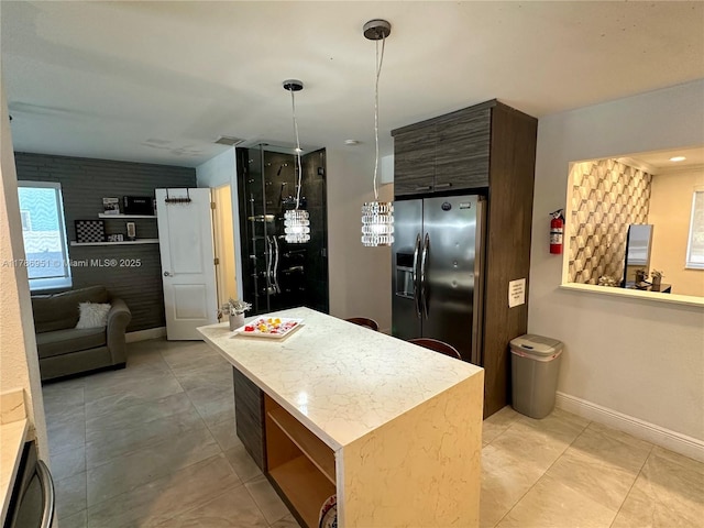 5424 Garfield St, Hollywood, FL 33021 - kitchen featuring stainless steel fridge, light countertops, a center island, baseboards, and hanging light fixtures