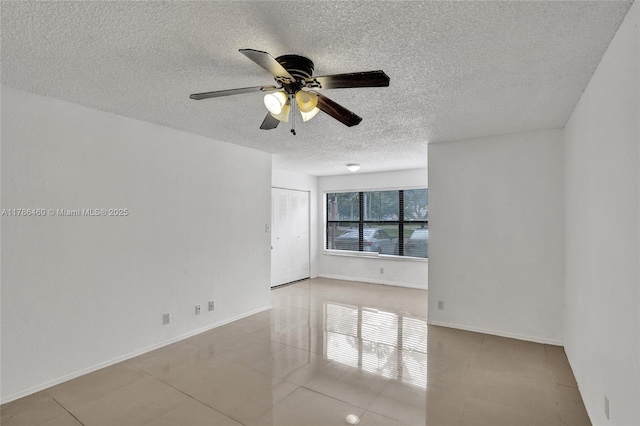 tiled spare room featuring a textured ceiling and ceiling fan