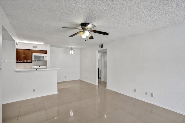 unfurnished living room featuring visible vents, a textured ceiling, and ceiling fan