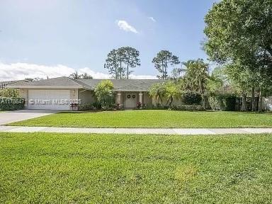 710 Daffodil Dr, Wellington, FL 33414 - single story home featuring concrete driveway, a front yard, and a garage