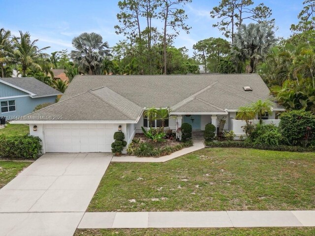 710 Daffodil Dr, Wellington, FL 33414 - single story home with a front yard, an attached garage, concrete driveway, and stucco siding