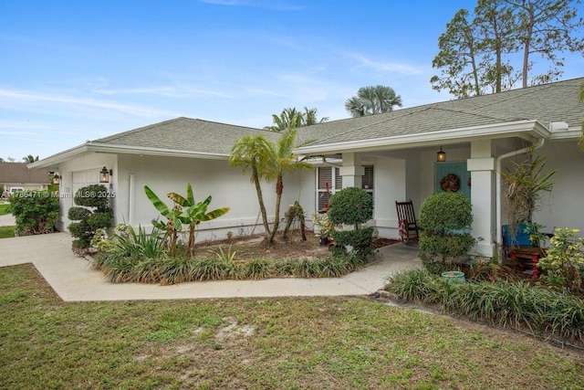 710 Daffodil Dr, Wellington, FL 33414 - view of front of house with a garage, a front lawn, a shingled roof, and stucco siding
