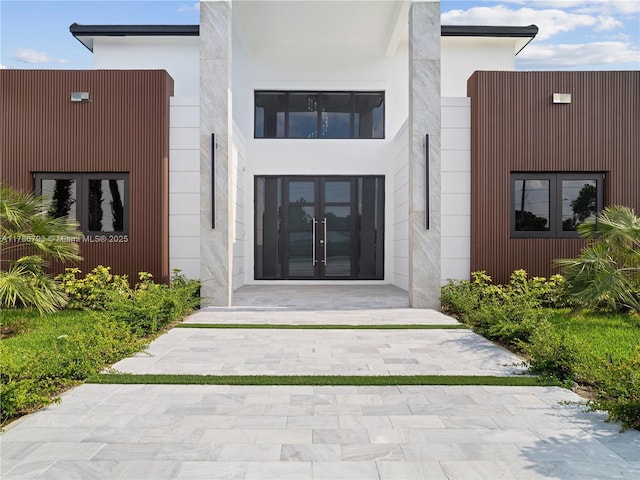 entrance to property featuring stucco siding and french doors