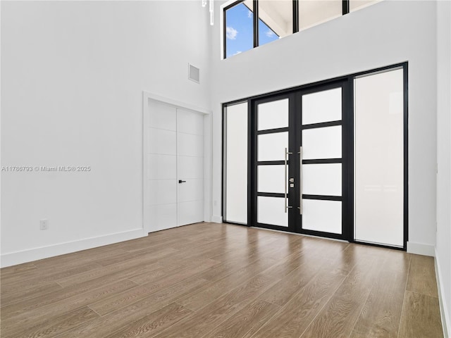 entryway with baseboards, wood finished floors, and visible vents