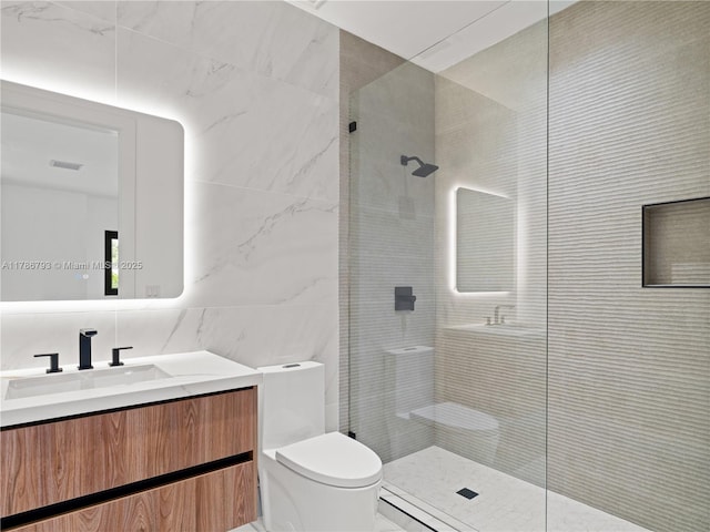 bathroom featuring visible vents, toilet, vanity, tile walls, and tiled shower
