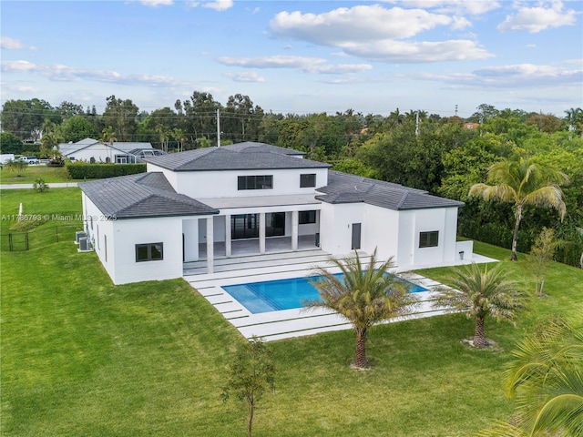 rear view of house featuring fence, an outdoor pool, a yard, and a patio