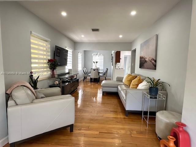 living area featuring recessed lighting, light wood-type flooring, and visible vents