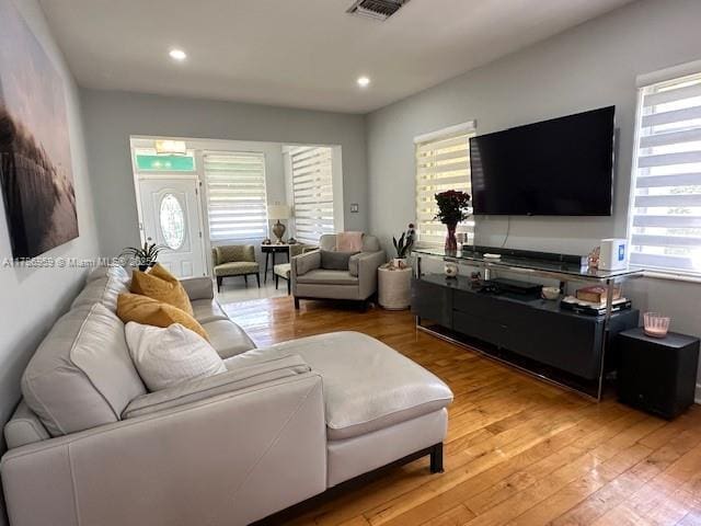living area featuring recessed lighting, light wood-style flooring, and visible vents