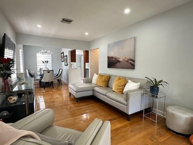 living area with recessed lighting, a chandelier, wood finished floors, and visible vents