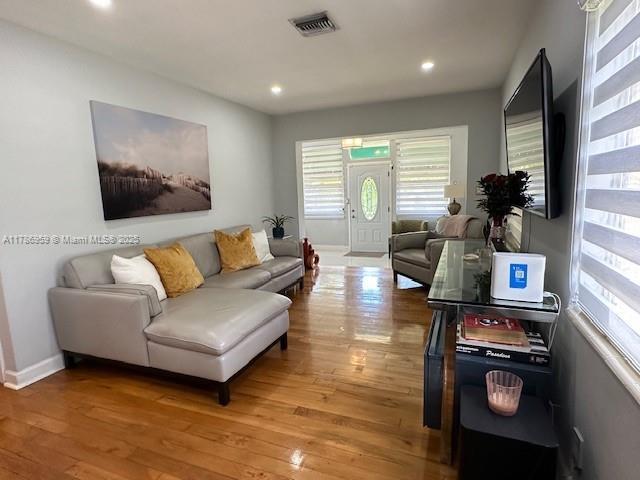 living area featuring baseboards, visible vents, recessed lighting, and light wood-style floors