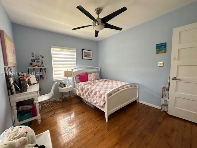 bedroom with ceiling fan, baseboards, and hardwood / wood-style floors