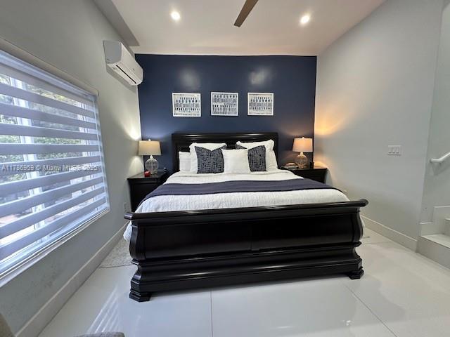bedroom with a wall mounted air conditioner, baseboards, and recessed lighting