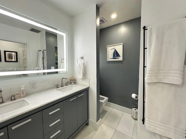 bathroom featuring tile patterned floors, visible vents, a sink, and toilet