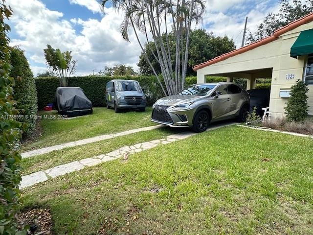 view of parking with driveway and an attached carport