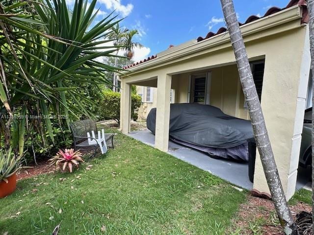 view of side of home with a lawn and stucco siding