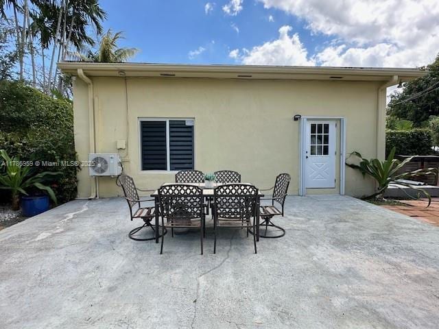 back of property with outdoor dining space, ac unit, a patio, and stucco siding