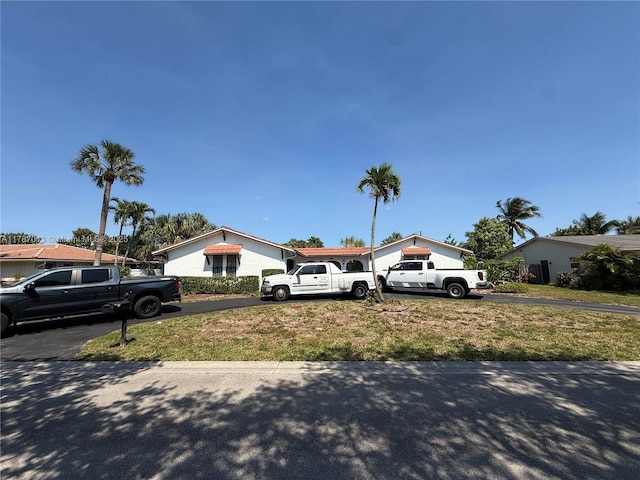 single story home featuring a front lawn