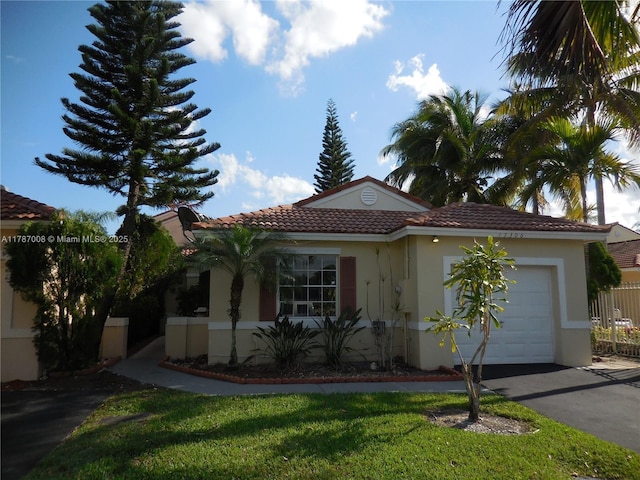 view of front of property with a front lawn, aphalt driveway, stucco siding, a tiled roof, and an attached garage