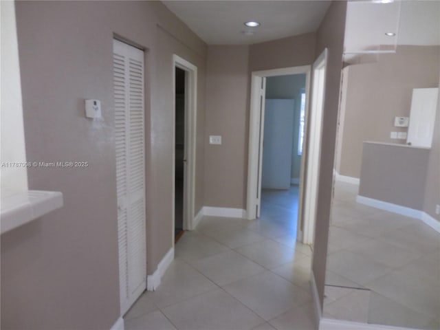hallway with baseboards and light tile patterned floors