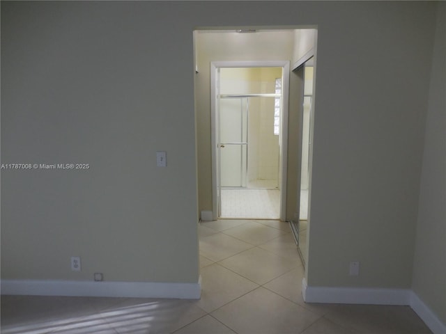 hallway with baseboards and light tile patterned flooring