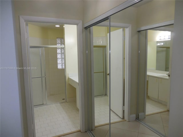 full bath with tile patterned flooring, a shower stall, and vanity