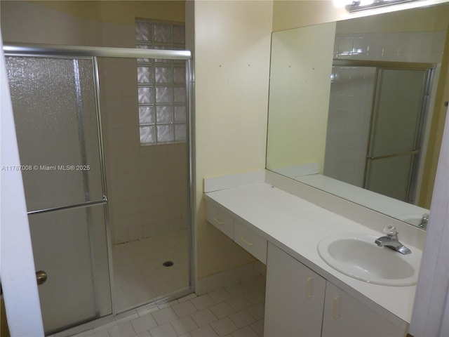 full bath featuring vanity, tile patterned flooring, and a stall shower