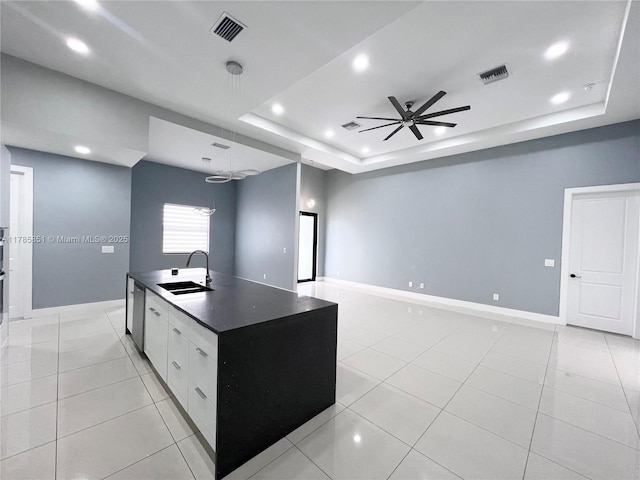 314 Chiquita Blvd N, Cape Coral, FL 33993 - kitchen with a sink, dark countertops, ceiling fan, a raised ceiling, and an island with sink