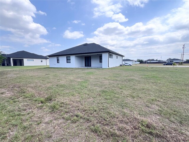 314 Chiquita Blvd N, Cape Coral, FL 33993 - rear view of house featuring a lawn and stucco siding