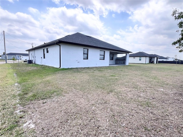 314 Chiquita Blvd N, Cape Coral, FL 33993 - back of house featuring a yard, stucco siding, a shingled roof, and central AC