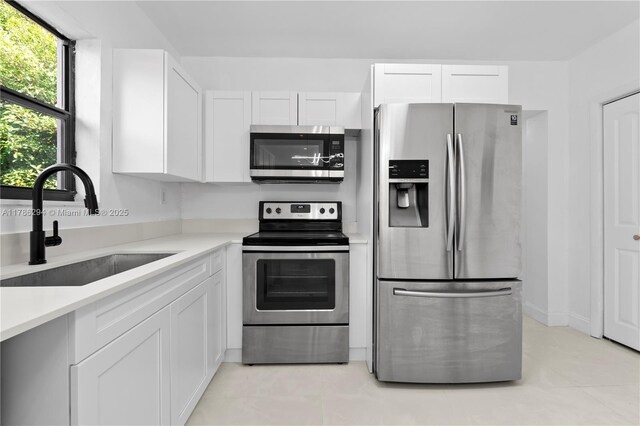 720 NW 6th St, Hallandale Beach, FL 33009 - kitchen featuring appliances with stainless steel finishes, a sink, white cabinets, and light countertops
