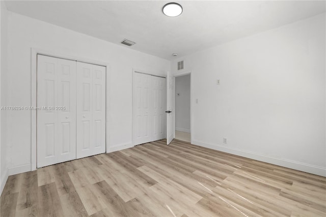720 NW 6th St, Hallandale Beach, FL 33009 - unfurnished bedroom featuring multiple closets, light wood-style flooring, and baseboards