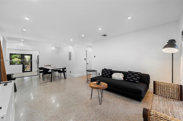 living area featuring speckled floor, visible vents, electric panel, and recessed lighting