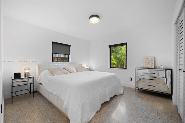bedroom with speckled floor and baseboards