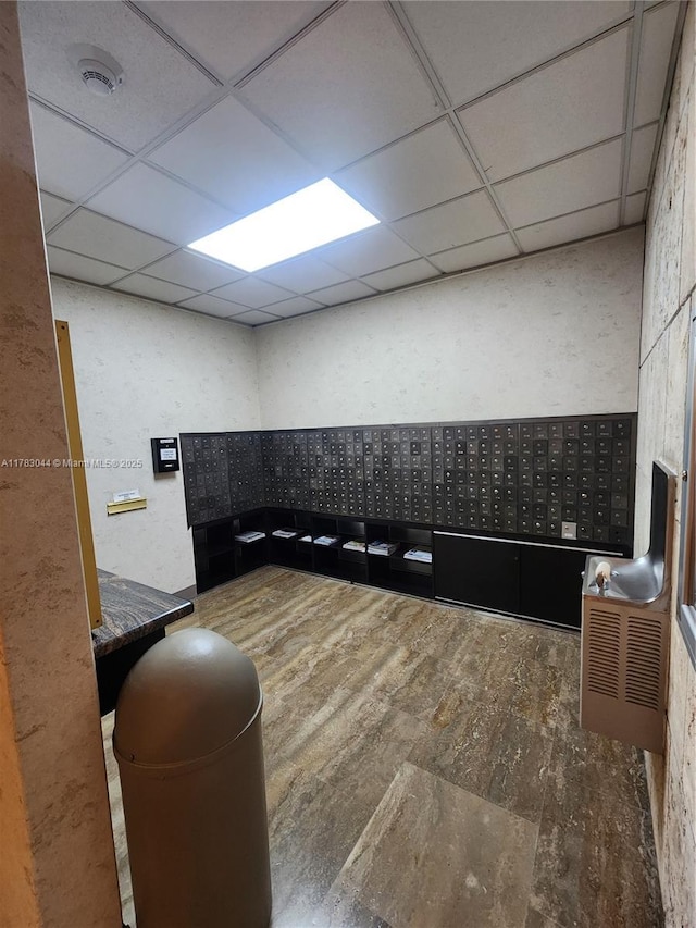 interior space featuring mail area and a drop ceiling