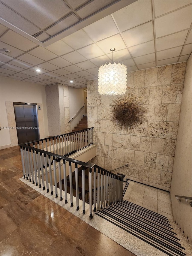 staircase with a drop ceiling and recessed lighting