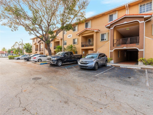 view of building exterior with uncovered parking and a residential view