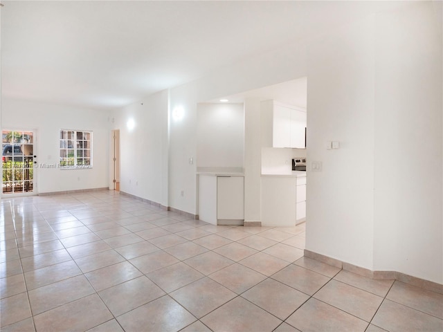 empty room featuring baseboards and light tile patterned floors