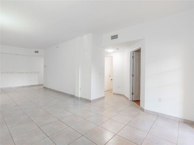 unfurnished room featuring baseboards, light tile patterned flooring, and visible vents