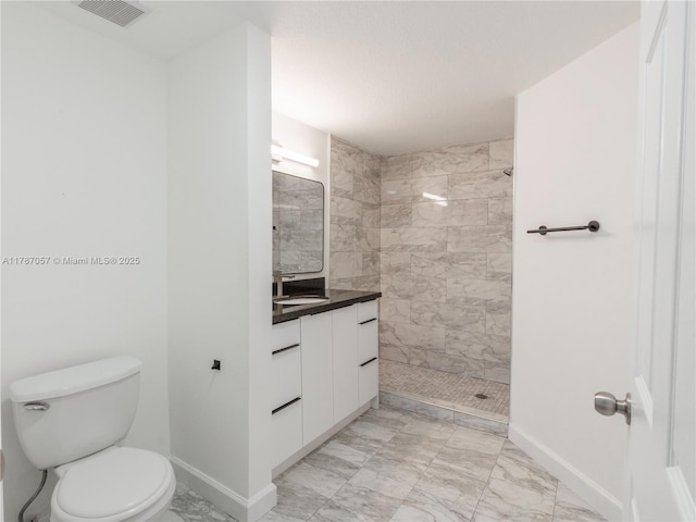 bathroom with toilet, tiled shower, visible vents, marble finish floor, and vanity