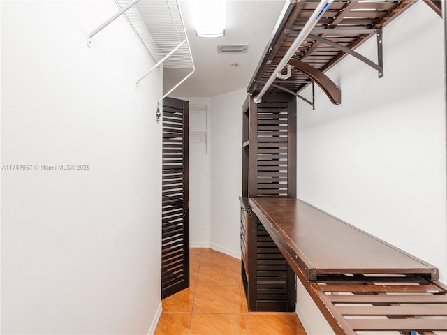 spacious closet featuring visible vents and light tile patterned floors