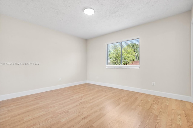 461 SE Evans Ave, Port St Lucie, FL 34984 - unfurnished room featuring light wood-style floors, a textured ceiling, and baseboards
