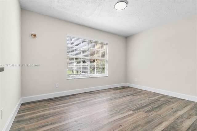 461 SE Evans Ave, Port St Lucie, FL 34984 - unfurnished room featuring wood finished floors, a textured ceiling, and baseboards
