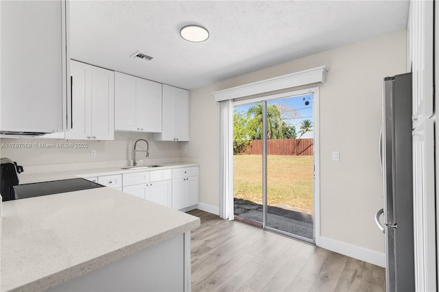 461 SE Evans Ave, Port St Lucie, FL 34984 - kitchen featuring electric stove, freestanding refrigerator, baseboards, a sink, and a textured ceiling