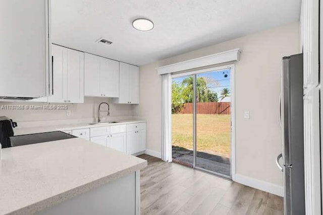 461 SE Evans Ave, Port St Lucie, FL 34984 - kitchen with range, freestanding refrigerator, baseboards, light countertops, and light wood-style floors