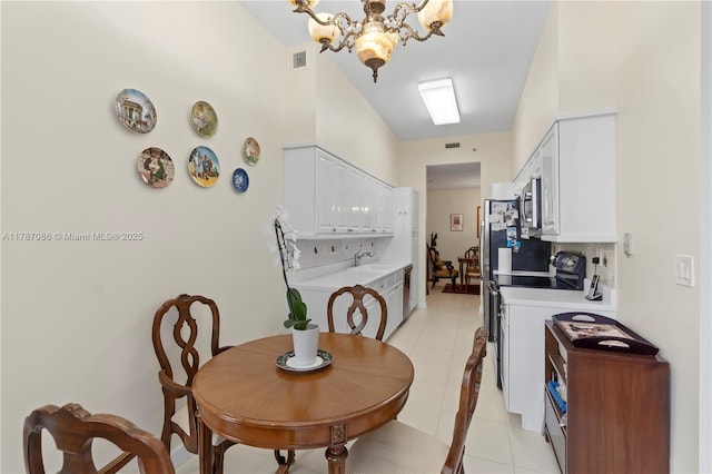 dining space with light tile patterned flooring, visible vents, and a notable chandelier
