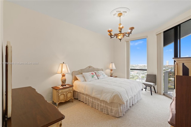 bedroom with access to outside, an inviting chandelier, and light colored carpet