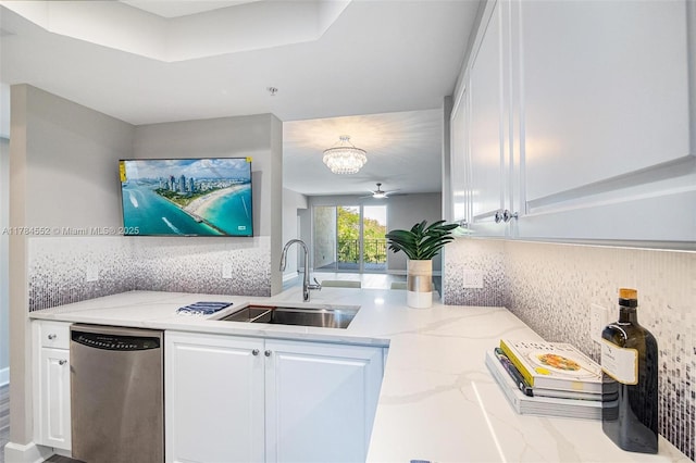 kitchen featuring stainless steel dishwasher, a sink, white cabinets, light stone countertops, and tasteful backsplash