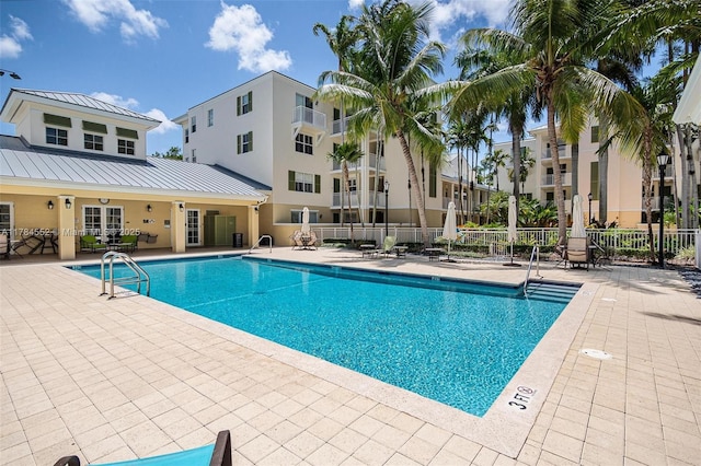 community pool featuring fence and a patio
